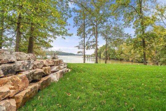 back yard lawn with stone wall and lake